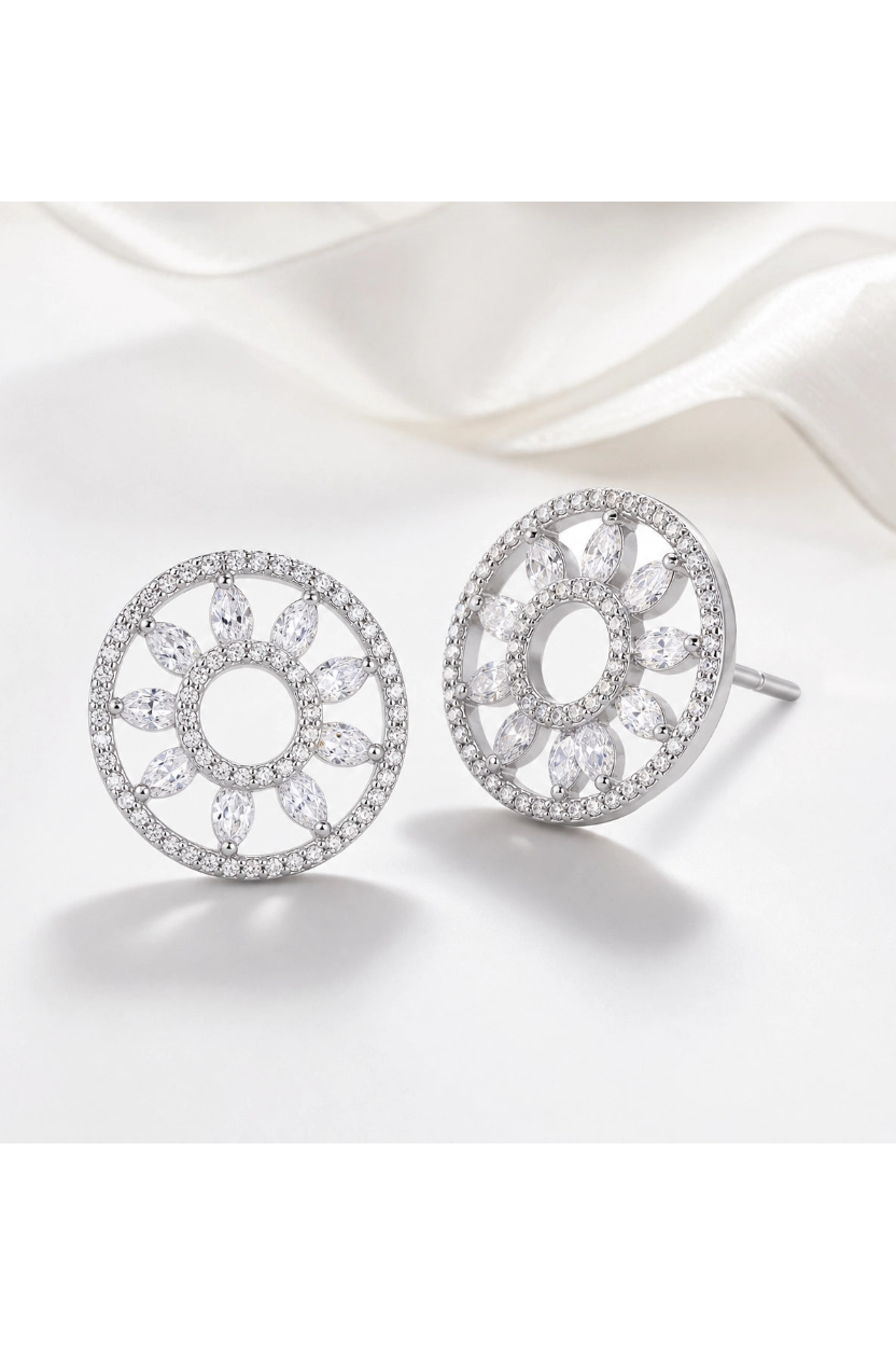 Pair of silver earrings with intricate designs on a white background